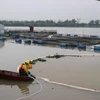 Nhân viên Trung tâm ứng phó sự cố môi trường Việt Nam đang xử lý thu gom dầu. (Ảnh: Mạnh Minh/TTXVN)