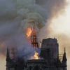 Tháp chuông bị sập khi lửa khói bao trùm nóc Nhà thờ Đức Bà ở Paris, Pháp. (Ảnh: AFP/TTXVN)