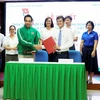 Đại diện lãnh đạo T.Ư Đoàn TNCS Hồ Chí Minh và Nestle Việt Nam trao biên bản ký kết hợp tác, giai đoạn 2020-2021. (Ảnh: Minh Hiếu/Vietnam+)