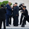 Tổng thống Mỹ Donald Trump (giữa, trái) bắt tay nhà lãnh đạo Triều Tiên Kim Jong-un (giữa, phải) tại Khu phi quân sự (DMZ) ở biên giới liên Triều chiều 30/6/2019.(Ảnh: AFP/TTXVN)