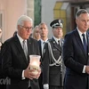 Tổng thống Đức Frank-Walter Steinmeier và Tổng thống Ba Lan Andrzej Duda thắp nến tưởng nhớ các nạn nhân. (Ảnh: PAP/TTXVN)