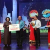 Chủ tịch Ủy ban MTTQ Việt Nam Thành phố Hồ Chí Minh Tô Thị Bích Châu tiếp nhận tượng trưng số tiền ủng hộ từ các nhà hảo tâm. (Ảnh: Xuân Khu/TTXVN)