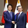 Tổng thống Hàn Quốc Moon Jae-in và Thủ tướng Nhật Bản Shinzo Abe. (Ảnh: Kyodo)