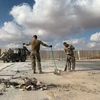 Binh sĩ Mỹ dọn dẹp đống đổ nát tại căn cứ không quân Ain al-Asad. (Ảnh: AFP/TTXVN)
