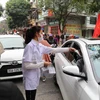 Nhân viên một cửa hàng thuốc tại Ninh Bình phát khẩu trang y tế miễn phí cho người dân. (Ảnh: Đức Phương/TTXVN)