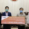 Đại diện Star Telecom trao tượng trưng số tiền ủng hộ tương đương 320.000 USD cho Chính phủ Lào. (Ảnh: Phạm Kiên/TTXVN) 