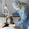 Chữa trị cho bệnh nhân COVID-19 tại Italy. (Ảnh: AFP/TTXVN)