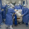 Nhân viên y tế chuyển bệnh nhân mắc COVID-19 tới phòng điều trị tích cực tại một bệnh viện ở Vũ Hán, Trung Quốc ngày 12/4. (Ảnh: THX/TTXVN)