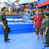 Bộ đội Biên phòng tỉnh Bà Rịa-Vũng Tàu kiểm tra việc thực hiện lắp thiết bị hành trình trên các tàu cá. (Ảnh: Hoàng Nhị/TTXVN) 