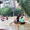 Người dân di thuyền qua khu vực ngập lụt sau mưa lớn tại Trung Quốc.(Ảnh: THX/ TTXVN)