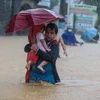 Người dân sơ tán khỏi vùng ngập lụt do bão Vamco tại Manila. (Ảnh: THX/TTXVN)