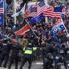 Người biểu tình ủng hộ Tổng thống Donald Trump đối đầu với cảnh sát. (Ảnh: AFP/TTXVN)