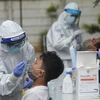 Nhân viên y tế lấy mẫu xét nghiệm COVID-19 tại Jakarta. (Ảnh: AFP/TTXVN)