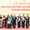 Chủ tịch nước Nguyễn Xuân Phúc tặng chân dung Chủ tịch Hồ Chí Minh cho đại diện gia đình và các cá nhân tại buổi lễ. (Ảnh: Thống Nhất/TTXVN)