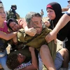 Những phụ nữ Palestine giằng co với một binh sỹ Israel để cứu cậu bé người Palestine trong cuộc biểu tình phản đối Israel tịch thu đất ở khu Bờ Tây. (Ảnh: AFP)