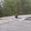 Một người đàn ông bị kẹt trong dòng nước lũ. (Nguồn: thebigwobble.org)