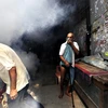 Nhân viên y tế Ấn Độ phun thuốc diệt muỗi để ngăn bùng phát dịch sốt xuất huyết. (Ảnh: AFP)