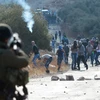 Binh sỹ Israel bắn đạn hơi cay vào người biểu tình Palestine ở khu Bờ Tây. (Ảnh: AFP/TTXVN)