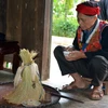 Thầy cúng làm lễ rồi dùng nước phun vào cụm lúa để cầu cho mưa thuận, gió hòa. (Ảnh: Thế Duyệt/TTXVN)