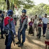 Cảnh sát Myanmar đứng cạnh những người Hồi giáo Rohingya. (Nguồn: New York Times)