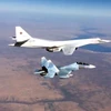 Tiêm kích Su-30SM hộ tống một máy bay ném bom siêu âm Tu-22 thực hiện nhiệm vụ không kích IS ở Syria. (Ảnh: Bộ Quốc phòng Nga)