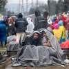 Người tị nạn chờ đợi qua khu vực biên giới Hy Lạp- Macedonia ngày 24/2. (Ảnh: AFP/TTXVN)