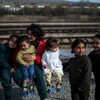 Người tị nạn Afghanistan chờ đợi giấy phép tại biên giới giữa Macedonia và Serbia ngày 21/2. (Ảnh: AFP/TTXVN)