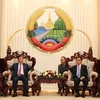 Thủ tướng Lào Thongsing Thammavong tiếp thân mật Bộ trưởng Bùi Quang Vinh. (Ảnh: Phạm Kiên/Vietnam+)