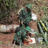 Lực lượng công binh lắp đặt thuốc nổ để hủy nổ quả bom. (Ảnh: Lê Hữu Quyết/TTXVN)