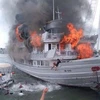 Du khách hốt hoảng nhảy khỏi con tàu cháy. (Ảnh: Nguyễn Hoàng/Vietnam+)