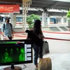 Hành khách đi qua máy kiểm tra thân nhiệt tại ga Sài Gòn. (Ảnh: Tiến Lực/TTXVN)