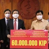 Ông Bounkong Syhavong (phải), Bộ trưởng Bộ Y tế, Phó Trưởng Ban chỉ đạo quốc gia về phòng chống dịch Covid -19 Lào tiếp nhận ủng hộ. (Ảnh: Phạm Kiên/TTXVN)