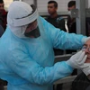 Nhân viên y tế Palestine lấy mẫu xét nghiệm COVID-19 cho người dân ở thành phố Hebron, Khu Bờ Tây, ngày 7/4/2020. (Ảnh: THX/TTXVN)