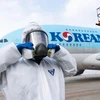 Nhân viên chuẩn bị phun thuốc khử trùng trên máy bay của Korean Air nhằm ngăn chặn sự lây lan của dịch COVID-19. (Ảnh: AFP/TTXVN)