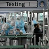 Nhân viên y tế lấy mẫu dịch xét nghiệm COVID-19 cho hành khách tại sân bay quốc tế Incheon, phía tây thủ đô Seoul, Hàn Quốc, ngày 1/4/2020. (Ảnh: AFP/TTXVN)
