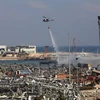 Máy bay nỗ lực dập lửa bốc ngùn ngụt tại hiện trường vụ nổ lớn ở khu cảng thủ đô Beirut, Liban ngày 4/8/2020. (Ảnh: AFP/TTXVN)