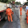 Lực lượng thi công gia cố các tấm thép trên mặt cầu An Viễn. (Ảnh: TTXVN phát)