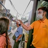 Người dân được kiểm tra thân nhiệt phòng lây nhiễm COVID-19 trước khi lên xe buýt tại Manila, Philippines, ngày 19/8/2020. (Ảnh: THX/TTXVN)