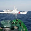 Tàu cảnh sát biển Việt Nam giám sát một tàu hải cảnh cảu Trung Quốc hoạt động trái phép tại Biển Đông. (Nguồn: Reuters)