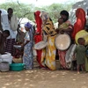 Phân phát lương thực viện trợ của Chương trình Lương thực thế giới (WFP) cho người dân tại trại tị nạn ở Mogadishu, Somalia. (Ảnh: AFP/TTXVN)