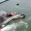 Lực lượng chức năng nỗ lực dập đám cháy tàu du lịch trên vịnh Hạ Long. (Ảnh: TTXVN phát)