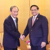 Thủ tướng Phạm Minh Chính gặp cựu Thủ tướng Nhật Bản Suga Yoshihide. (Ảnh: Dương Giang/TTXVN)