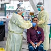 Nhân viên y tế lấy mẫu xét nghiệm COVID-19 cho người dân tại Singapore. (Ảnh: AFP/TTXVN)
