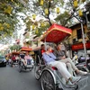 Du khách nước ngoài sử dụng xích lô dạo quanh phố phường, thưởng ngoạn nét đẹp cổ kính của Hà Nội. (Ảnh: Thanh Tùng/TTXVN)