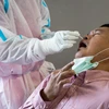 Nhân viên y tế lấy mẫu xét nghiệm COVID-19 cho người dân tại Bangkok, Thái Lan. (Ảnh: AFP/TTXVN)