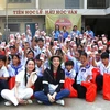 Hoa hậu Hòa bình Quốc tế 2021 Nguyễn Thúc Thùy Tiên chụp ảnh cùng các em học sinh người gốc Việt tại Trường Tiểu học Hữu nghị Khmer-Việt Nam Tân Tiến. (Ảnh: Hoàng Minh/TTXVN)