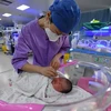 Y tá chăm sóc một đứa trẻ sơ sinh ở bệnh viện nhi tại tỉnh An Huy, Trung Quốc ngày 17/1/2024. (Ảnh: AP)