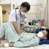 Bác sỹ thăm khám cho bệnh nhi đang điều trị tại Bệnh viện Đa khoa Xanh Pôn. (Ảnh: Minh Quyết/TTXVN)