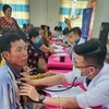 Các thầy thuốc trẻ tổ chức khám bệnh, cấp thuốc miễn phí cho người dân xã ven biển Nam Thái A, huyện An Biên, tỉnh Kiên Giang. (Ảnh: TTXVN phát)