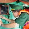 Lực lượng Biên phòng kiểm tra niêm phong, kẹp chì thiết bị giám sát hành trình trước khi tàu cà xuất bến đánh bắt hải sản trên biển. (Ảnh: Huỳnh Sơn/TTXVN)